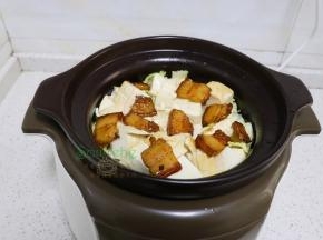 把炒的大白菜，倒入炖砂锅，接着放入煎好的豆腐、五花肉，一小碗高汤，没有高汤就加一小碗沸水。