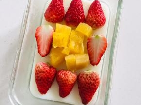 快要凝固的时候放入切好的草莓和菠萝！（放晚了水果不容易和牛奶这一层很好的粘住！）