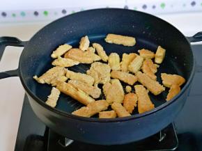 起油锅，加入素鸡条煎至金黄。