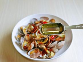 取出蒸好的花蛤，淋上一勺热油。