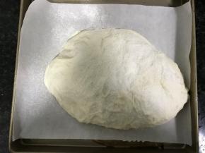 放入烤箱发酵至1.5倍大左右，表面撒上面粉