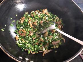 锅烧热放少许油，先放咸肉丝翻炒至变色，大概2分钟左右，然后加入大蒜翻炒，为了好包，大蒜切小段。