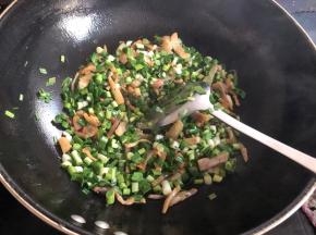 锅烧热放少许油，先放咸肉丝翻炒至变色，大概2分钟左右，然后加入大蒜翻炒，为了好包，大蒜切小段。
