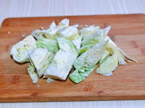 首先将卷心菜冷水冲洗一下，再切小块。