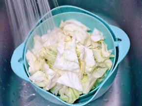 切好的卷心菜冷水冲洗干净，并将卷心菜洗散开。