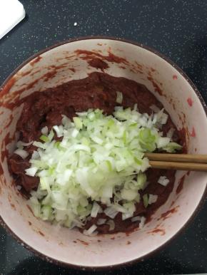 面团静置时间快到的时候把牛肉馅取出来，加上切好的大葱碎。