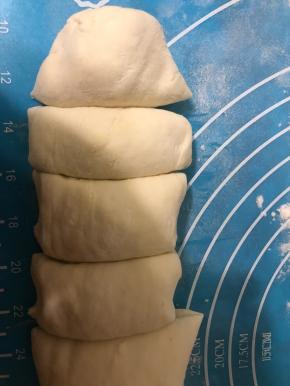 案板上撒面粉，面团取出不揉面，直接搓成长条，分成12等份。