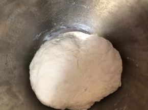 面粉里加入180g清水搅匀，揉成面团，盖上盖子静置半小时。