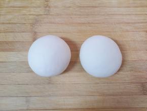 饧好的面团分成两份揉光，盖上保鲜膜。