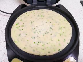 电饼铛预热，刷上一层食用油，放入做好的饼胚，饼的表面也刷上一层食用油。