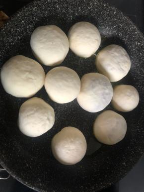 平底锅大火烧热，放油，把肉饼坯子收口朝下码入锅里，盖上锅盖，改小火，煎一会。