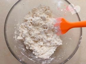 将酵母水倒入面粉里，搅拌成絮状。