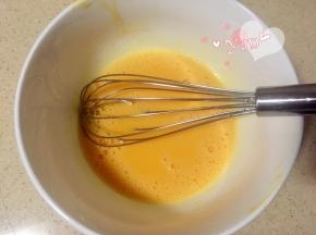蛋黄里加入玉米油，用蛋抽划一字翻拌均匀。