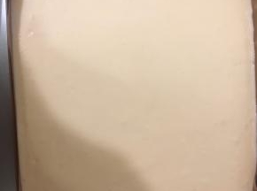 从高处倒入到事先铺好油布的28×28的烤盘中，抹平表面。