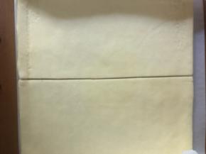 晾凉后，翻面，撕去油布，从中间切开分成两个一样大小的小块。