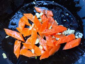 另起锅倒入底油加热放入蒜粒爆香再放入胡萝卜炒至变色