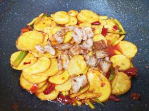 下入煎好的五花肉翻炒入味。