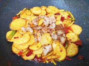下入煎好的五花肉翻炒入味。