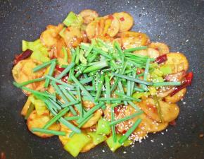 下入小蒜蒜叶部分和熟白芝麻，翻炒均匀关火出锅。