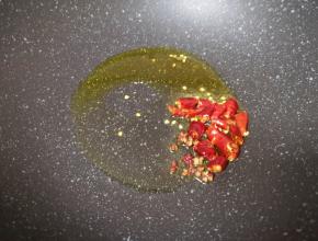 炒锅内倒适量的食用油烧热，下入干红辣椒和花椒爆香。