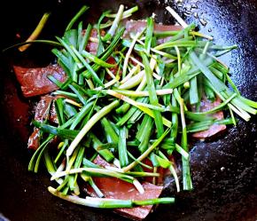 放入韭菜段同时放入盐和味精开始翻炒均匀入味即可出锅