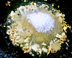 锅中倒入底油加热放入葱姜蒜爆香再放入糖