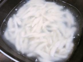 锅里烧一锅水，水微沸后转最小火，把面团取出用剪刀剪成均匀的小条