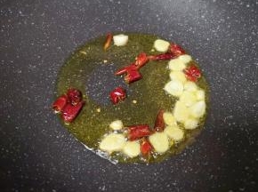 炒锅内倒适量的食用油烧热，下入蒜片和干红辣椒爆香。