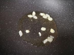 炒锅内继续倒油烧热，下入蒜片炒香。
