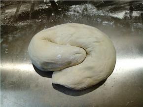 案板上抹一层薄薄的干粉，将发酵好的面团拍平，上下左右反复折叠两三次，然后搓成长条，左右折叠再搓揉也是反复两三次。如果粘手，手上也可以拍点干粉。