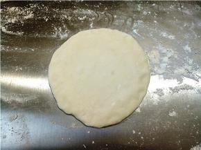 取一个小剂子，擀成比饺子皮大一点点，中间厚，边缘捏薄一点。