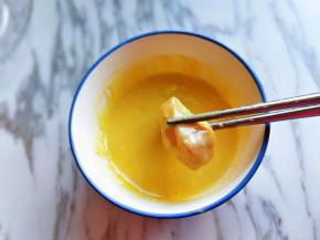 之后用筷子夹起腌制好的龙利鱼，放入蛋糊中，使龙利鱼挂满面糊。