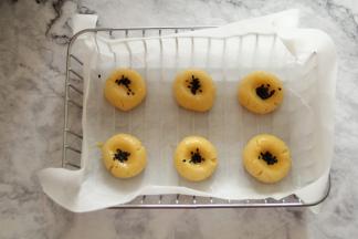 带手套将面团略按扁，刷点全蛋液，撒上芝麻。