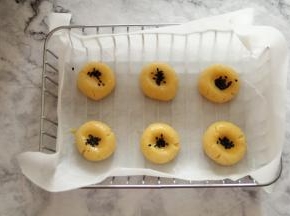 带手套将面团略按扁，刷点全蛋液，撒上芝麻。