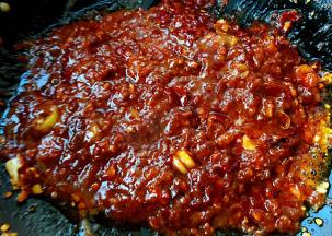 放入糖、郫县豆瓣酱炒匀再放入火锅麻辣底料炒匀