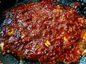放入糖、郫县豆瓣酱炒匀再放入火锅麻辣底料炒匀