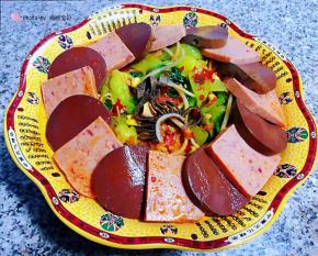 将入味的午餐肉、毛肚、鸭血、木耳摆放在蔬菜上面