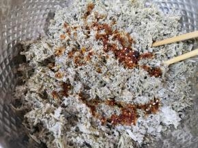 蒸好的白蒿麦饭放在盆里，根据自己的口味放盐、鸡精、香醋、生抽、香油和辣椒油。