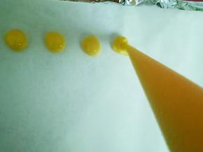 烤盘铺油纸，把蛋黄糊挤入烤盘中。
溶豆挤得小一点，这样容易烤熟。
挤一半的时候烤箱预热。