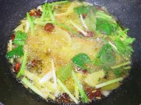 炒锅内倒入菜籽油烧热，下入准备好的小葱、洋葱、生姜、胡萝卜、芹菜和八角、桂皮、草果、香叶和小茴香，小火炸至所有食材微微焦黄。