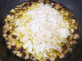 杏鲍菇和香菇炸至体积明显变小的时候下入金针菇翻炒均匀。