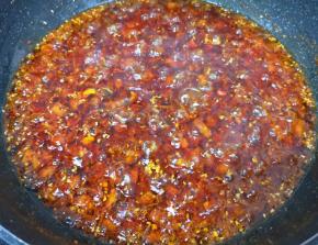 转小火炒至辣椒出红油，冰糖碎融化。