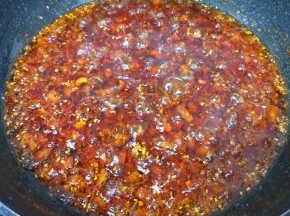 转小火炒至辣椒出红油，冰糖碎融化。