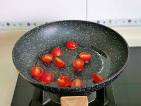 起油锅，倒入切好的小番茄块，翻炒至番茄变软。