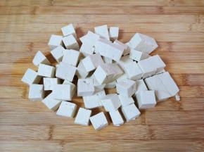 老豆腐用水冲洗一下，切成2厘米大小的方块。