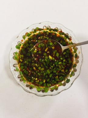 碗中放入韭菜末（或者葱末，家里葱用完了我用的韭菜也很好吃！），蒜末，一勺辣椒油，两勺生抽，两勺香醋，一勺糖，少许盐，少许鸡精，一勺五香粉，一勺孜然粉，一勺香油搅拌均匀调成料汁儿！