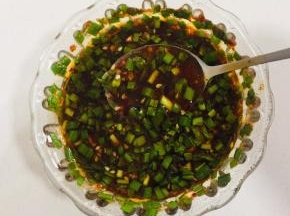 碗中放入韭菜末（或者葱末，家里葱用完了我用的韭菜也很好吃！），蒜末，一勺辣椒油，两勺生抽，两勺香醋，一勺糖，少许盐，少许鸡精，一勺五香粉，一勺孜然粉，一勺香油搅拌均匀调成料汁儿！