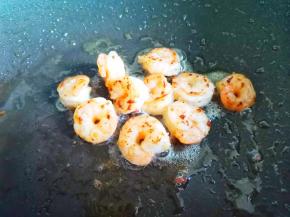 另起锅加油，加虾仁煎至变红，