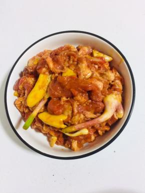 羊肉中放入姜片，两勺料酒，一勺玉米淀粉，蒜苗段，50克奥尔良烤肉料，适量食用油，两勺生抽抓拌均匀腌制半小时！