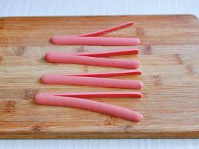 取一半火腿肠从中间切开，顶端不要切开，如图。